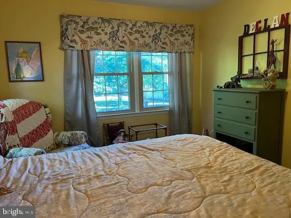 a bedroom with a bed and a dresser next to a window