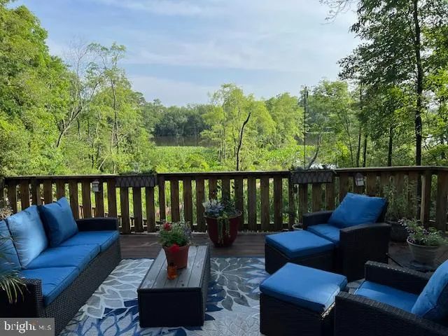 a balcony with wooden floor and outdoor seating