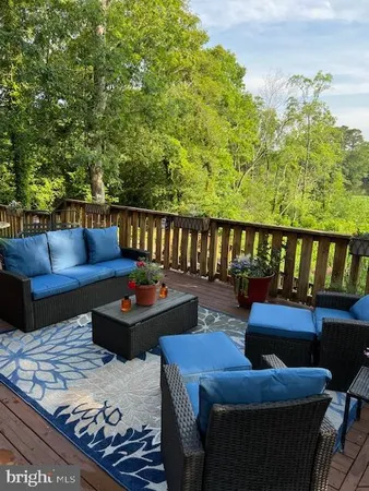 a roof deck with couches and wooden floor