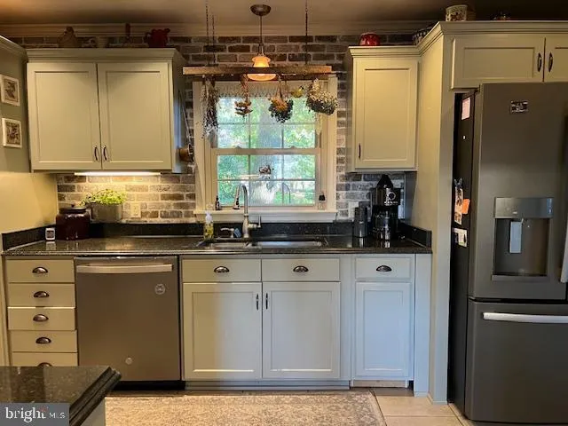 a kitchen with stainless steel appliances granite countertop a sink and a refrigerator