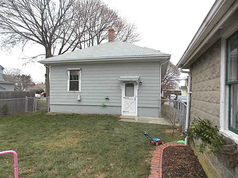 56 Richland Road Cranston, RI 02910 - Photo 18 of 20 Exterior Back. View of the back of the home with its fenced yard and garage to the right side of the picture.