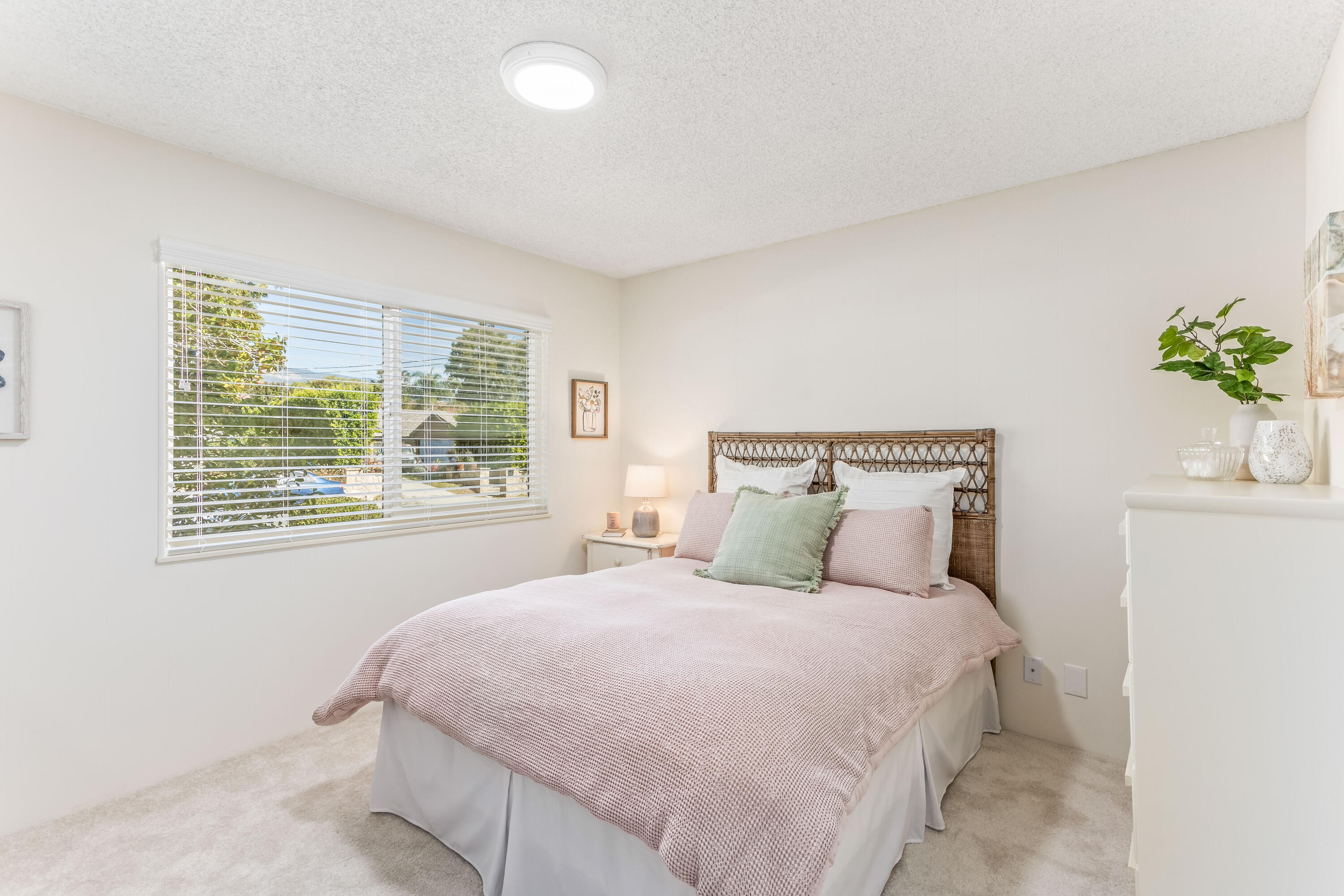 7111 Madera Drive Goleta, CA 93117 - Photo 13 of 24 a large bed sitting in a bedroom next to a window and a potted plant