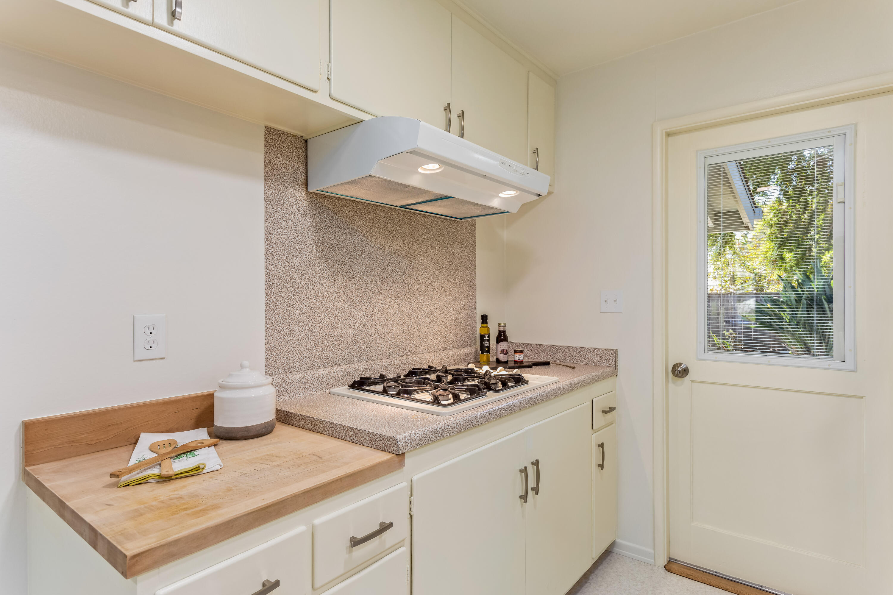 7111 Madera Drive Goleta, CA 93117 - Photo 10 of 24 a white kitchen with stainless steel appliances a stove a sink dishwasher and cabinets with wooden floor