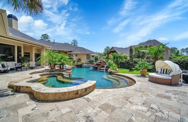 a view of a swimming pool with potted plants and palm trees