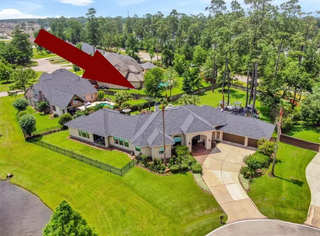 an aerial view of a house with swimming pool and garden
