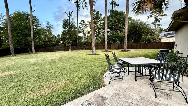 a backyard of a house with table and chairs