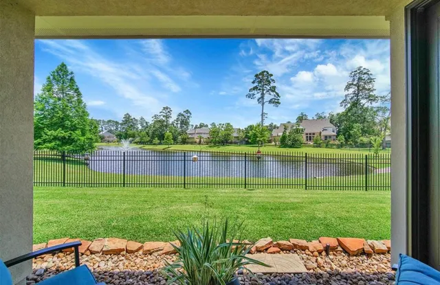 a backyard of a house with lots of green space and fountain
