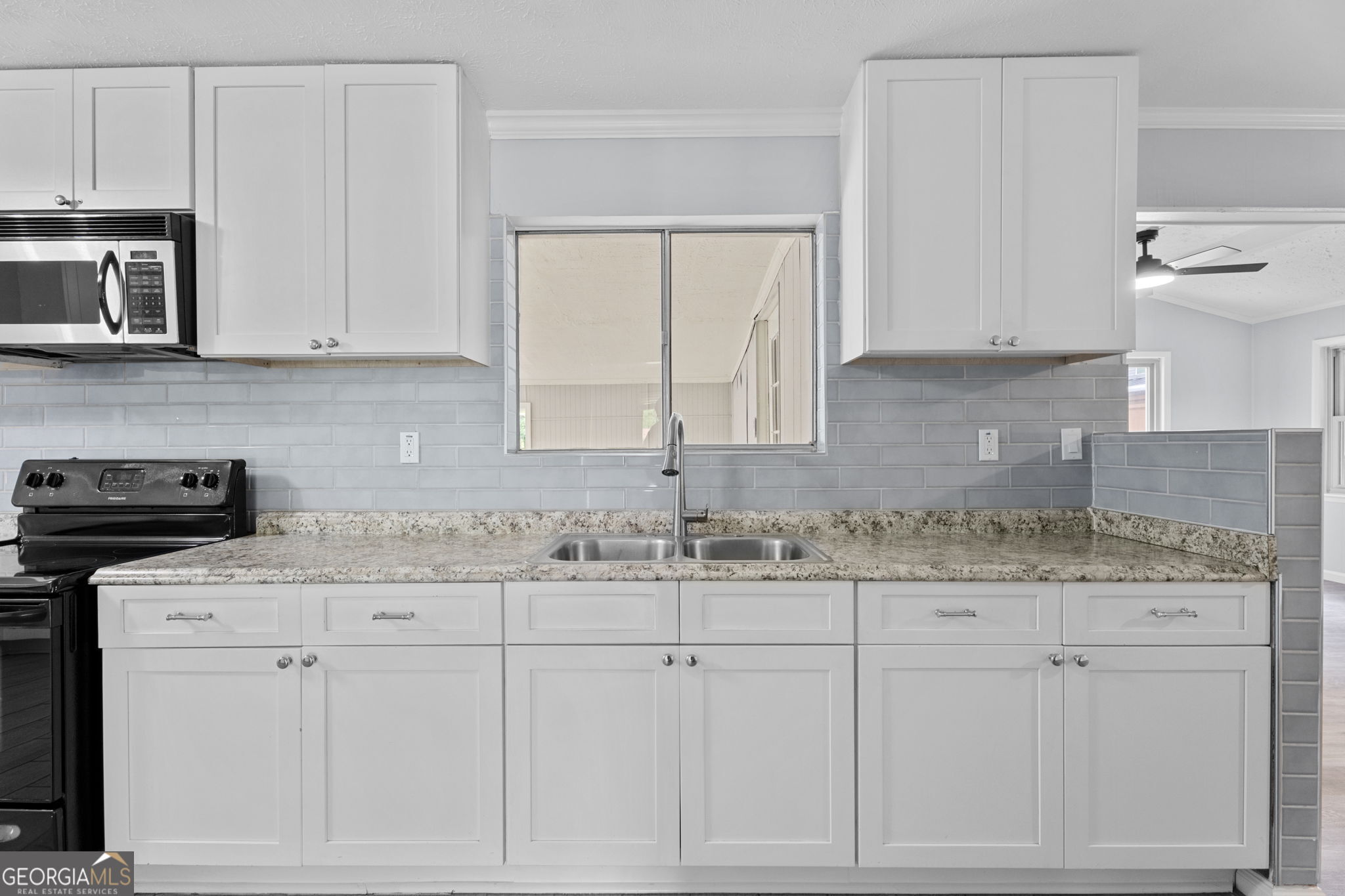 6463 Maddox Road Morrow, GA 30260 - Photo 11 of 46 a kitchen with granite countertop white cabinets and white appliances