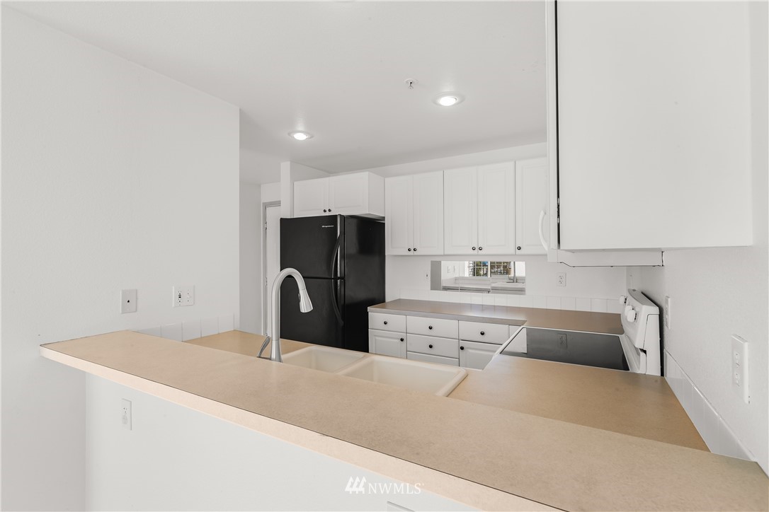 1160 Monroe Avenue Northeast, Unit A4 Renton, WA 98056 - Photo 18 of 26 a kitchen with a refrigerator sink and cabinets