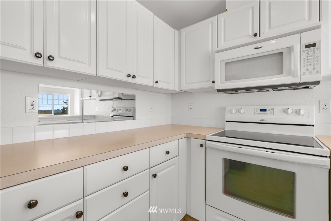 1160 Monroe Avenue Northeast, Unit A4 Renton, WA 98056 - Photo 4 of 26 a kitchen with white cabinets and white appliances