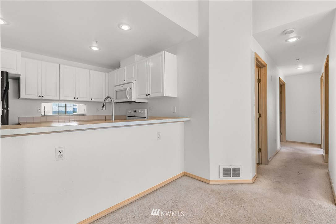 1160 Monroe Avenue Northeast, Unit A4 Renton, WA 98056 - Photo 7 of 26 a kitchen with stainless steel appliances granite countertop a refrigerator sink and cabinets