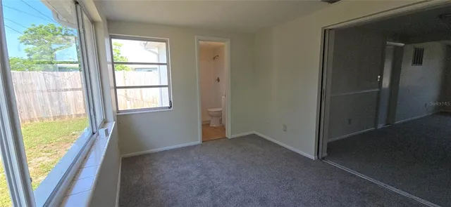 a view of a house with a large window and wooden fence