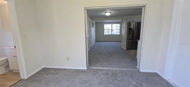 a view of a backyard with large trees and wooden fence