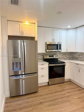 a kitchen with stainless steel appliances a stove a sink and a microwave