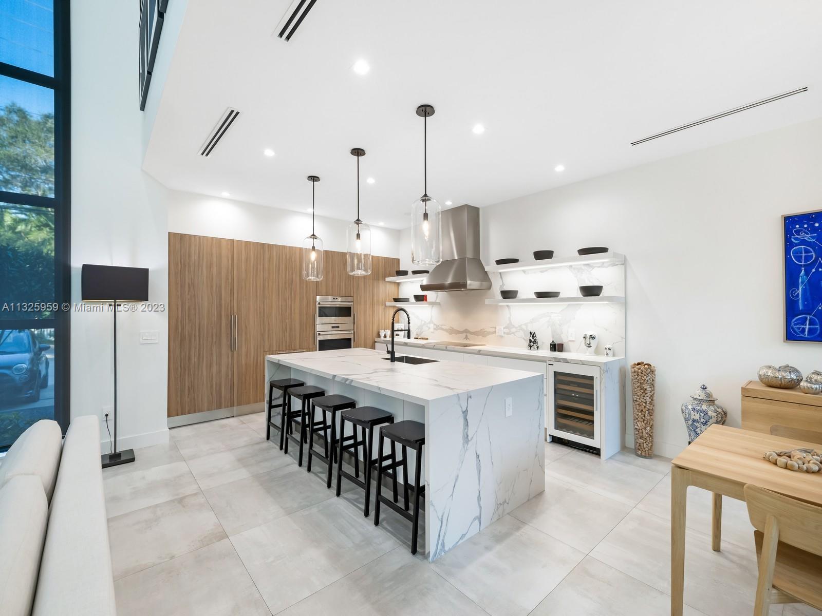 7260 School House Road Miami, FL 33143 - Photo 11 of 44 a kitchen with stainless steel appliances a stove a refrigerator a oven and white cabinets with wooden floor