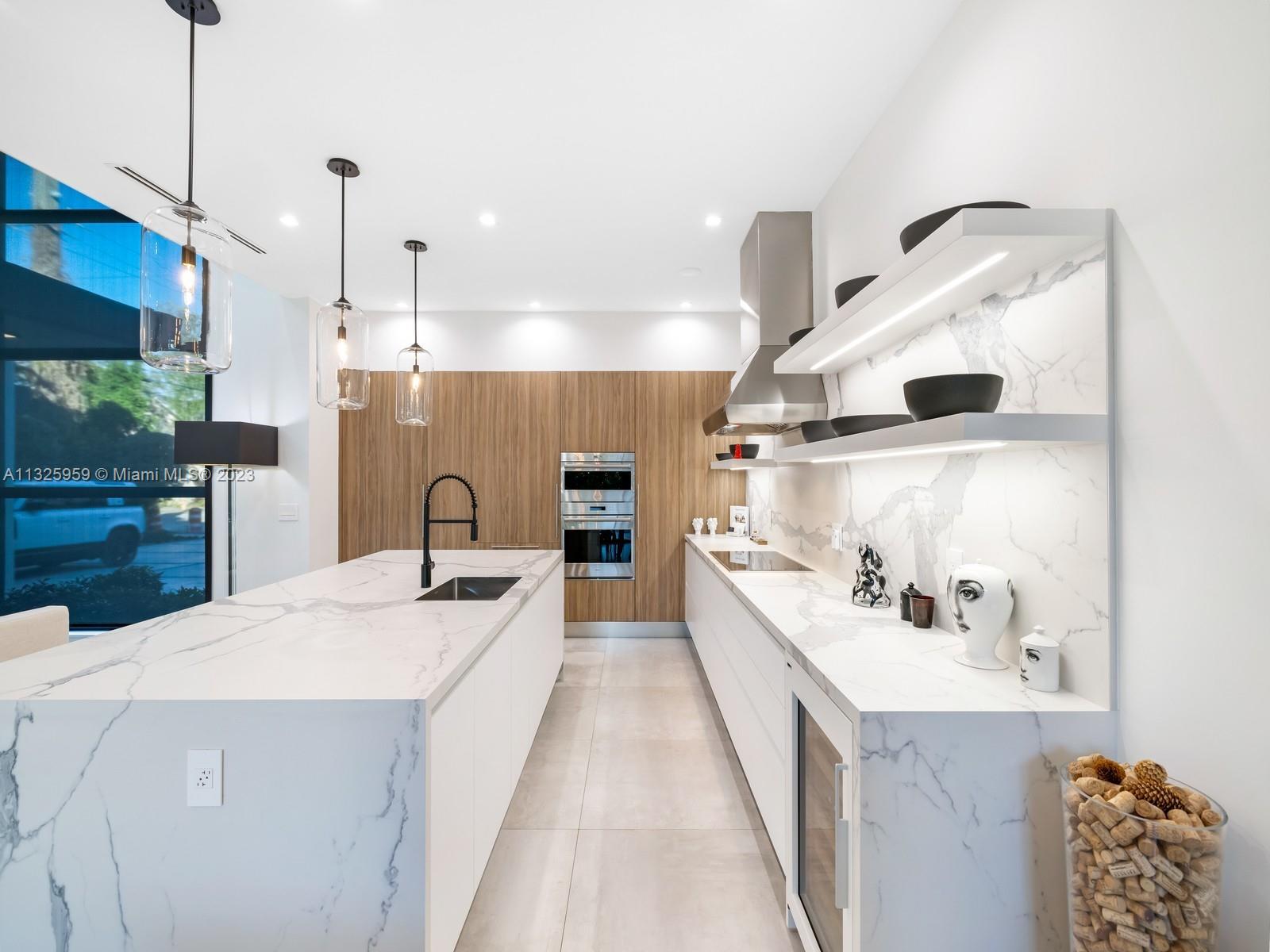 7260 School House Road Miami, FL 33143 - Photo 12 of 44 a large kitchen with kitchen island a sink stainless steel appliances and cabinets