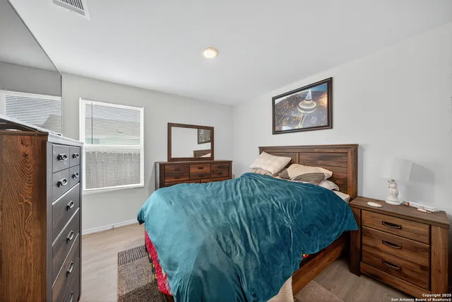 a bedroom with a bed and a flat tv screen on the dresser