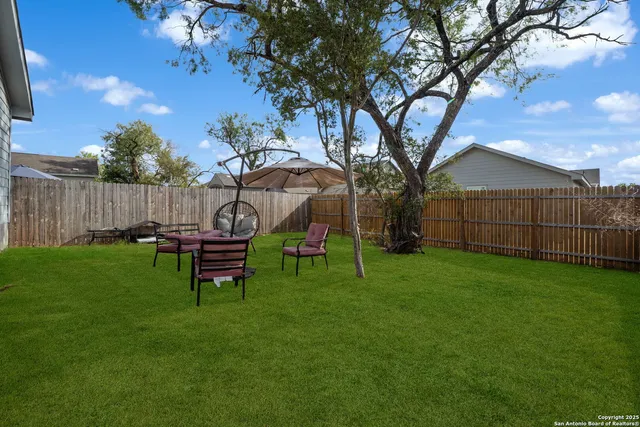 a view of a backyard with table and chairs and a fire pit