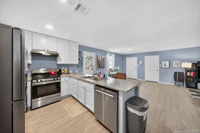 a kitchen with stainless steel appliances granite countertop a sink stove and refrigerator