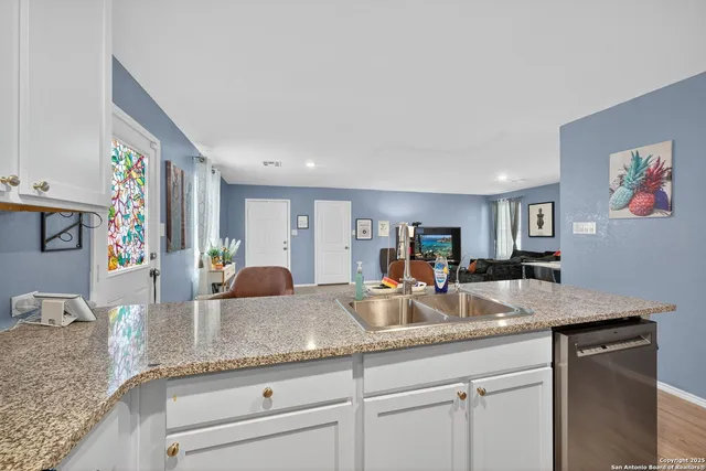 a kitchen with granite countertop a sink and cabinets