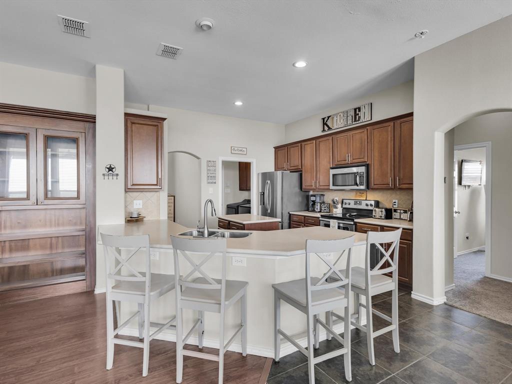 205 King George Road Ponder, TX 76259 - Photo 11 of 32 a kitchen with stainless steel appliances kitchen island granite countertop a stove top oven a sink dishwasher and a refrigerator