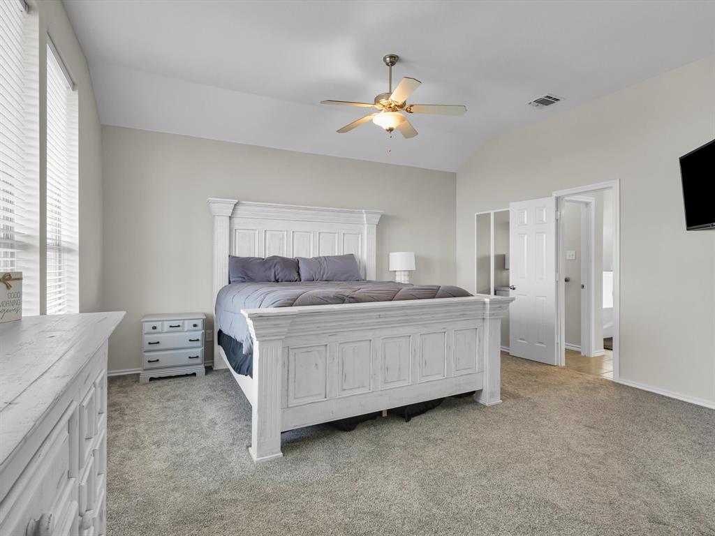 205 King George Road Ponder, TX 76259 - Photo 15 of 32 a bedroom with a bed and a chandelier