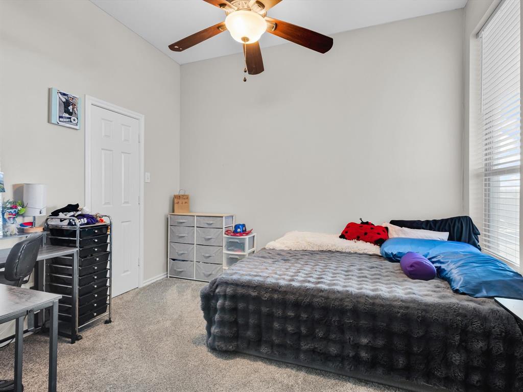 205 King George Road Ponder, TX 76259 - Photo 21 of 32 a bedroom with a bed and a chandelier