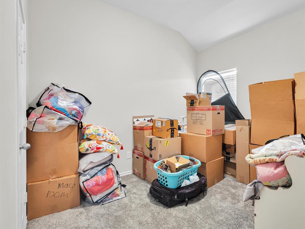 205 King George Road Ponder, TX 76259 - Photo 22 of 32 a bedroom with a bed and a chandelier
