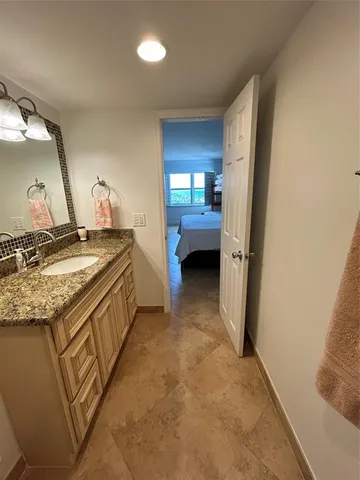 a bathroom with a granite countertop sink and mirror