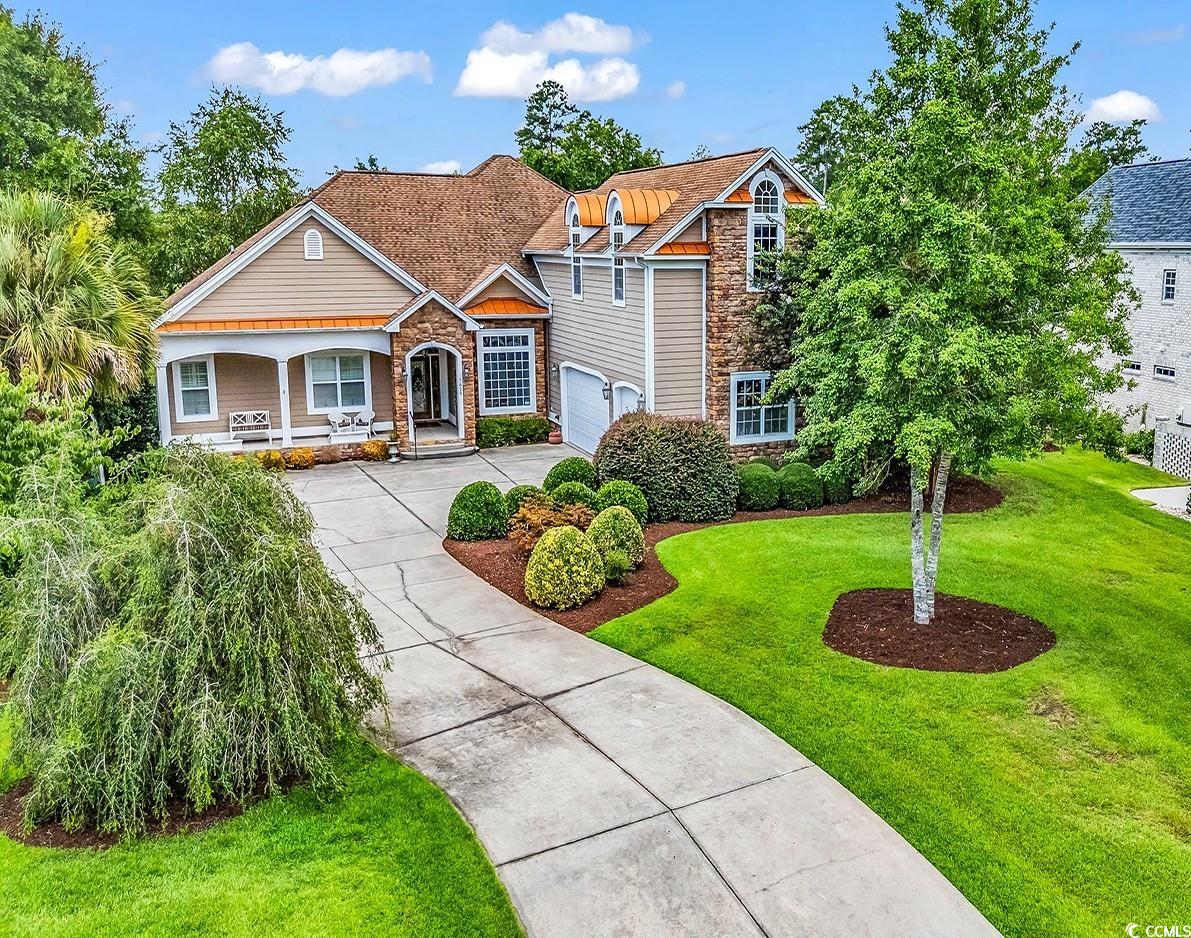7029 Byrnes Lane Myrtle Beach, SC 29588 - Photo 1 of 40 View of front facade with concrete driveway, a front yard, a garage, a porch, and stone siding