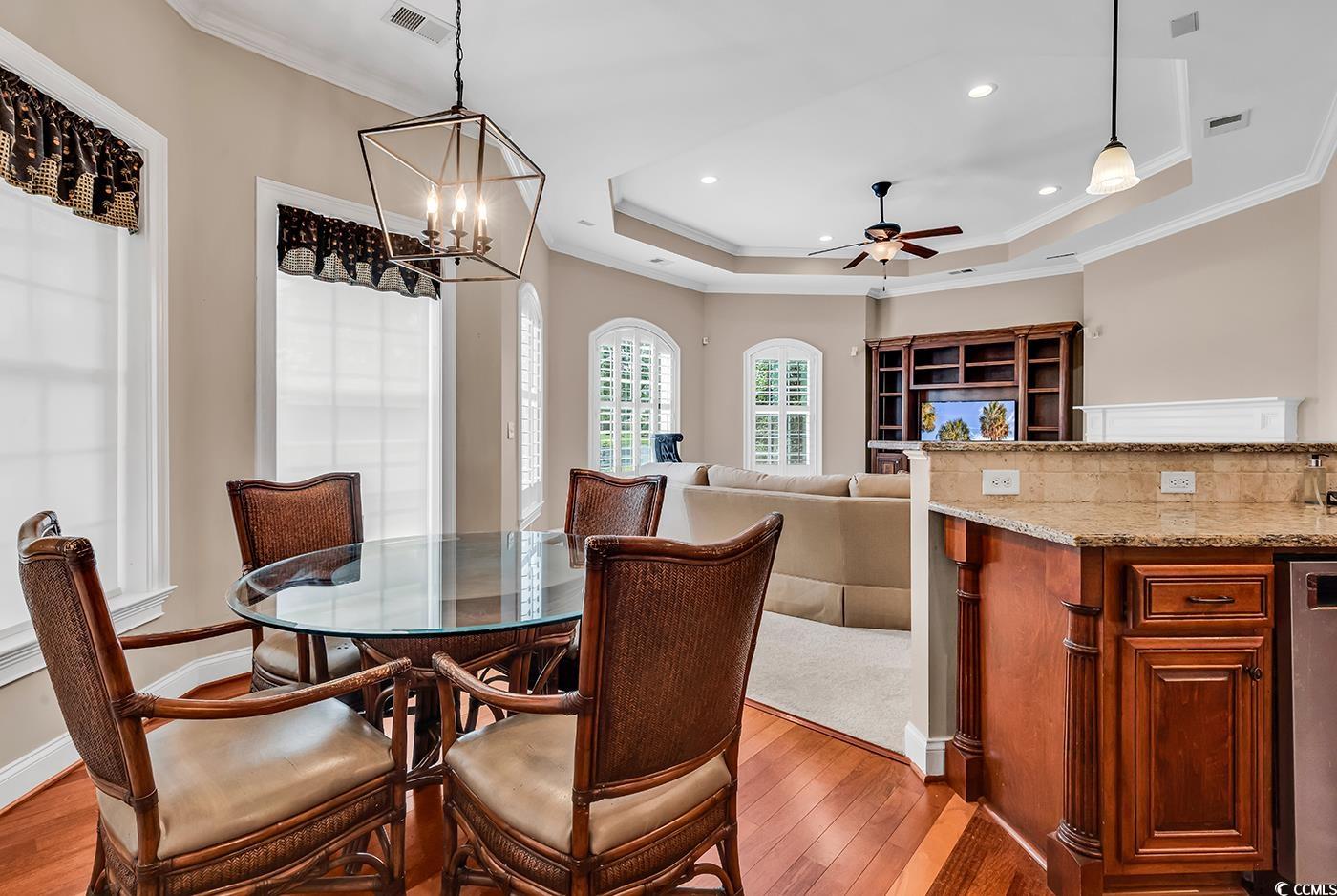 7029 Byrnes Lane Myrtle Beach, SC 29588 - Photo 12 of 40 Dining room featuring light wood finished floors, a tray ceiling, ceiling fan, recessed lighting, and a chandelier