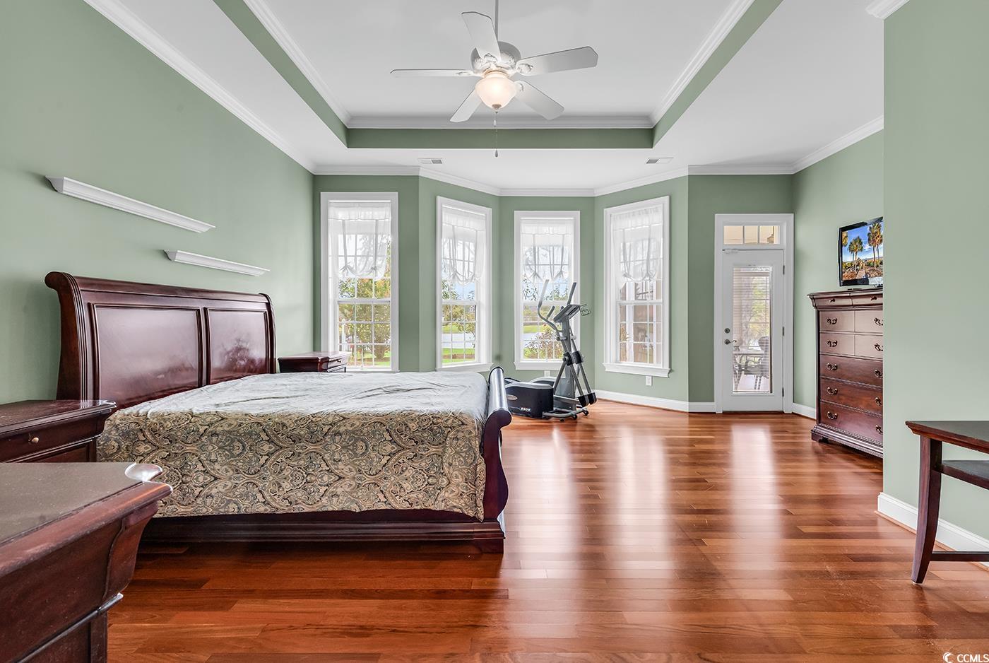 7029 Byrnes Lane Myrtle Beach, SC 29588 - Photo 19 of 40 Bedroom with a raised ceiling, wood finished floors, access to outside, ornamental molding, and a ceiling fan