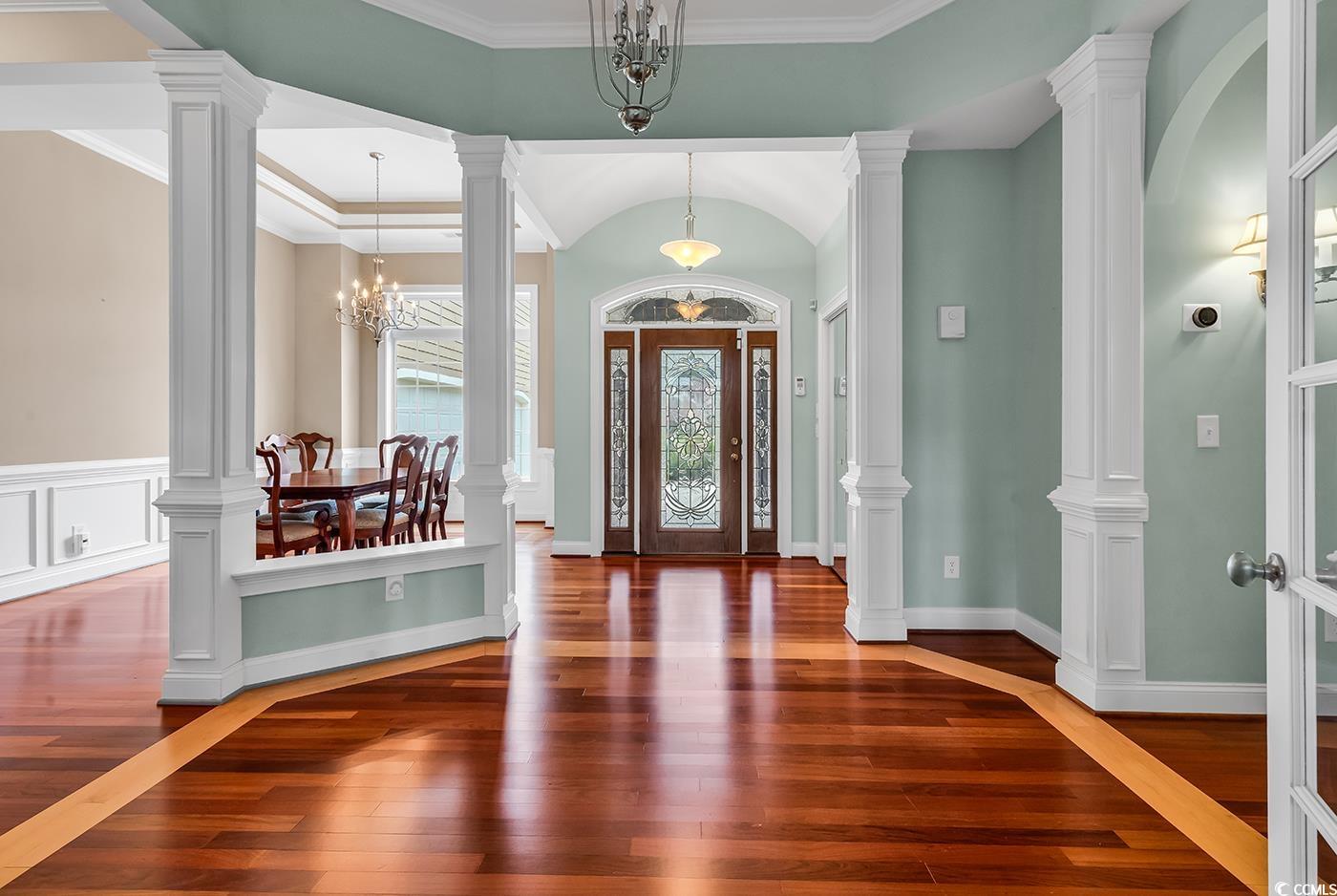 7029 Byrnes Lane Myrtle Beach, SC 29588 - Photo 2 of 40 Foyer entrance featuring wood-type flooring, a chandelier, and crown molding