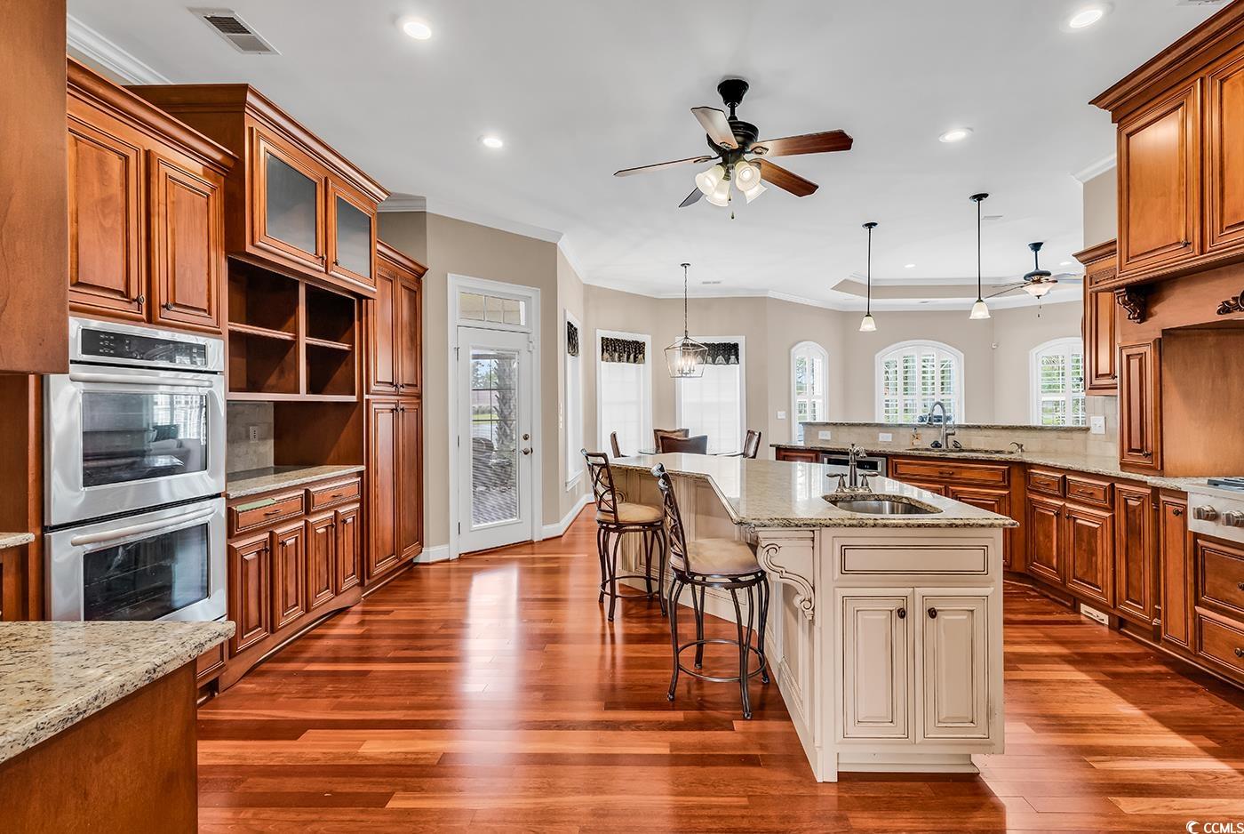 7029 Byrnes Lane Myrtle Beach, SC 29588 - Photo 7 of 40 Kitchen with ceiling fan, stainless steel double oven, recessed lighting, a kitchen breakfast bar, and tasteful backsplash