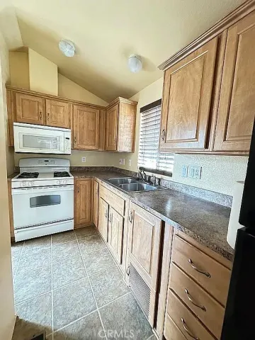 a kitchen with granite countertop a sink stainless steel appliances and cabinets