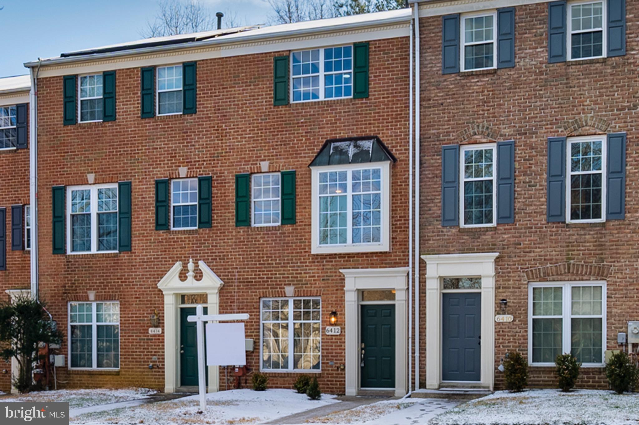 a front view of a building with a tree