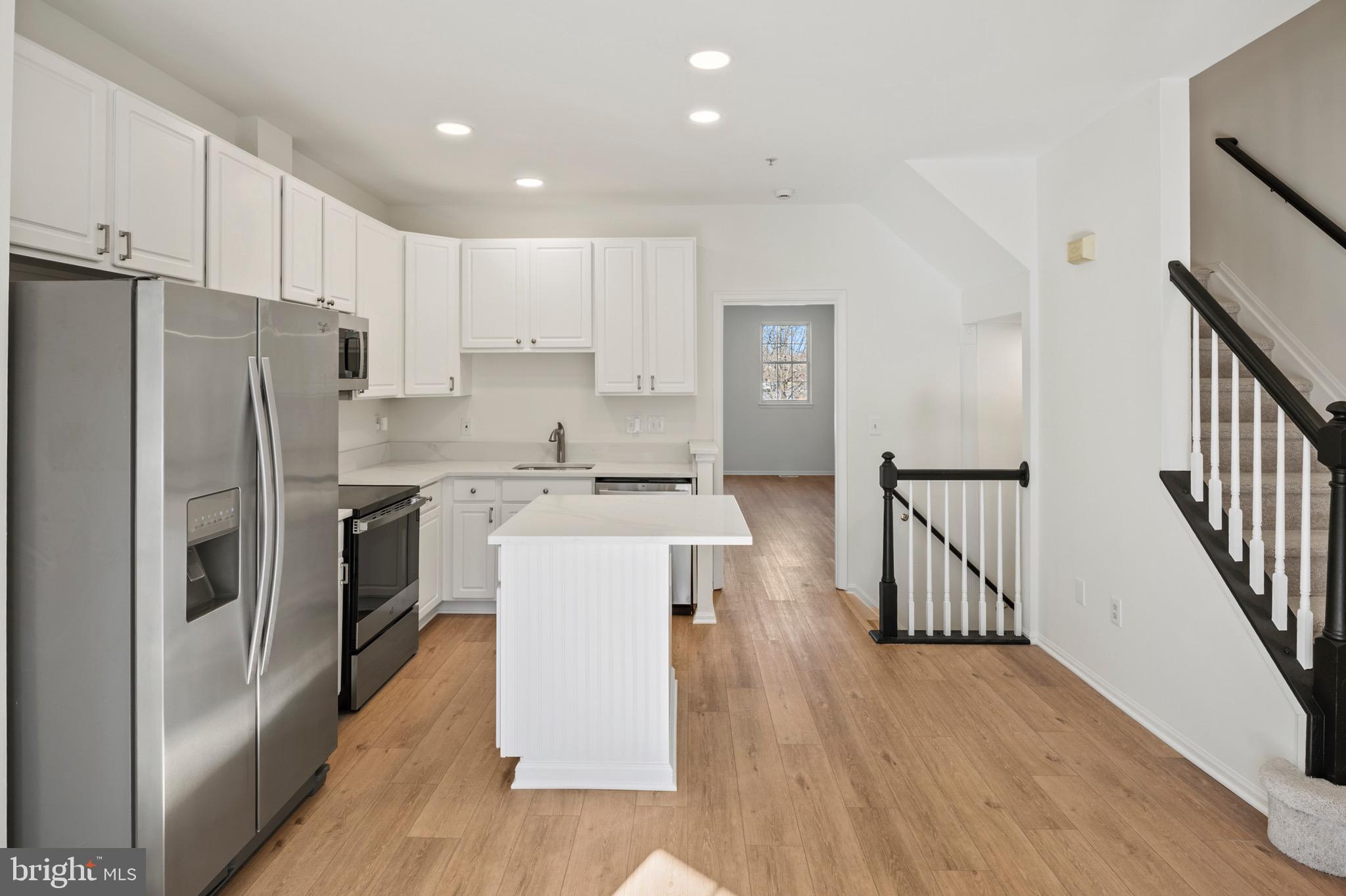 6412 Wind Rider Way Columbia, MD 21045 - Photo 3 of 37 a kitchen with kitchen island stainless steel appliances a refrigerator and a stove top oven