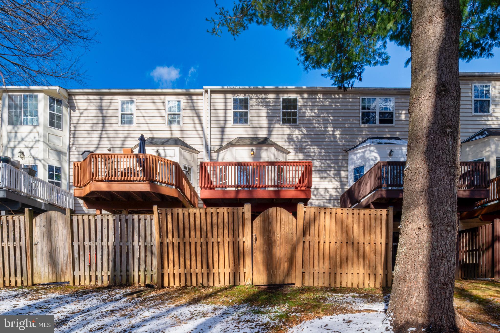 6412 Wind Rider Way Columbia, MD 21045 - Photo 33 of 37 a view of a brick house with large windows and wooden fence