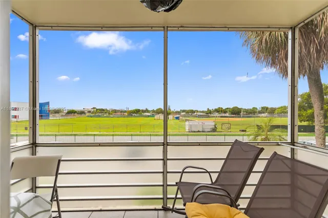 a view of a balcony with a floor to ceiling window next to a yard