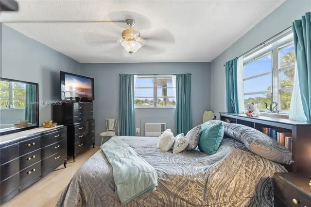 a bedroom with a large bed and a flat tv screen on dresser