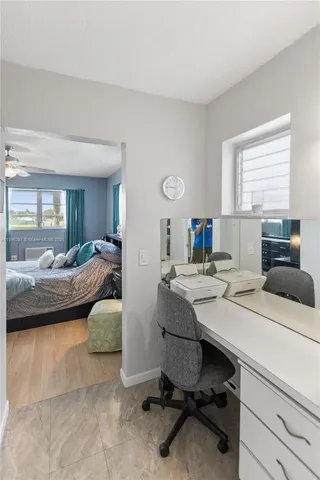 a view of a workspace with furniture and a window