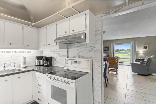 a kitchen with cabinets appliances a sink and a counter top space