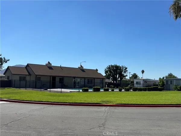 a view of a big house with a big yard and potted plants