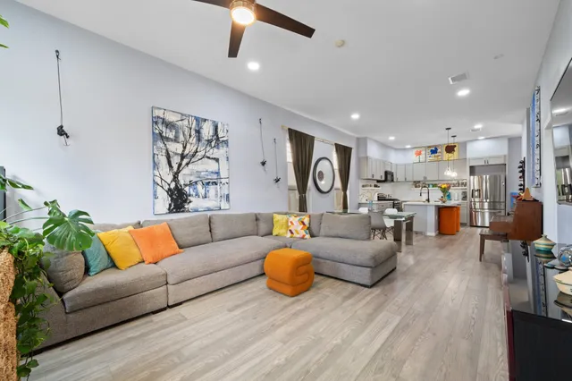 a living room with furniture kitchen view and a chandelier