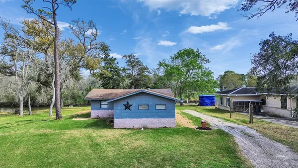 an aerial view of a house with a yard and large trees