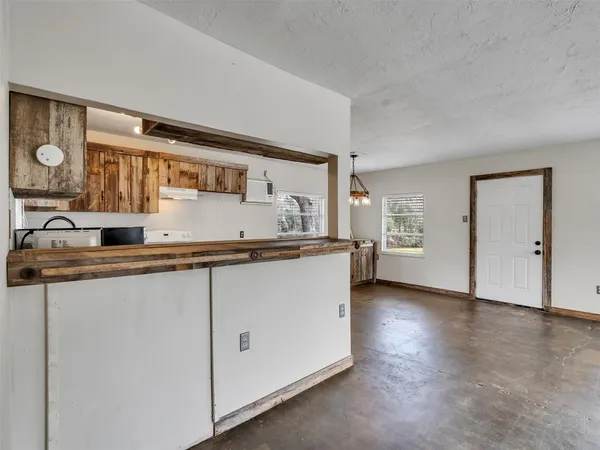 a view of an empty room with a kitchen