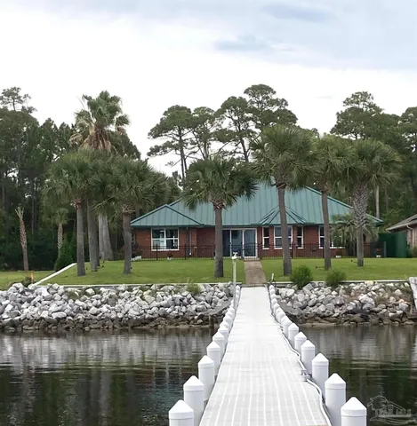 a front view of a house with a yard and potted plants