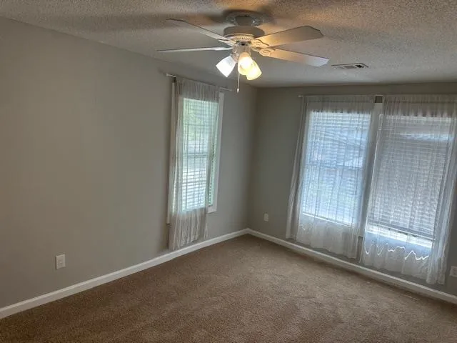 an empty room with chandelier fan