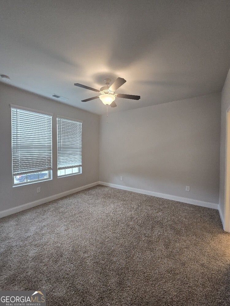 3405 Ripple Loop, Unit 127 Atlanta, GA 30349 - Photo 20 of 26 en empty room with windows and chandelier fan