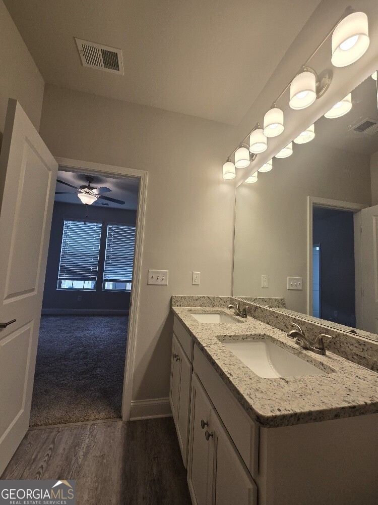 3405 Ripple Loop, Unit 127 Atlanta, GA 30349 - Photo 23 of 26 a bathroom with a granite countertop sink a toilet and a mirror
